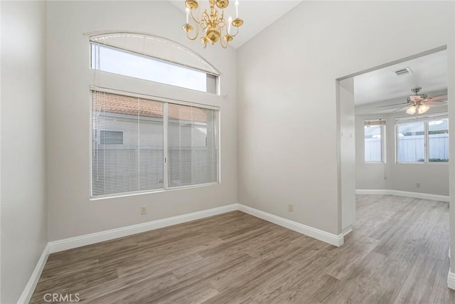 unfurnished room with vaulted ceiling, light wood-style flooring, and baseboards