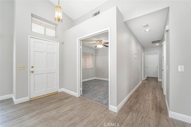 foyer featuring light wood finished floors, visible vents, baseboards, and ceiling fan