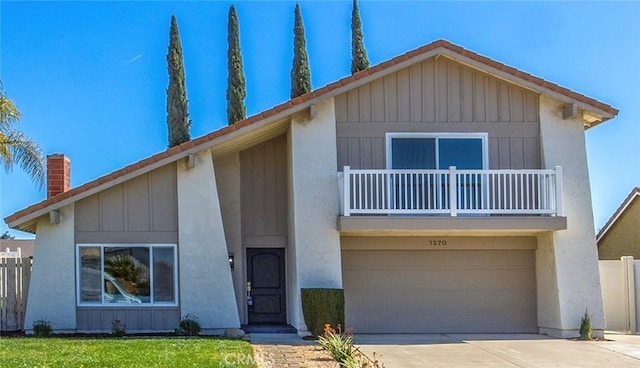 view of front facade with driveway, a balcony, an attached garage, fence, and board and batten siding