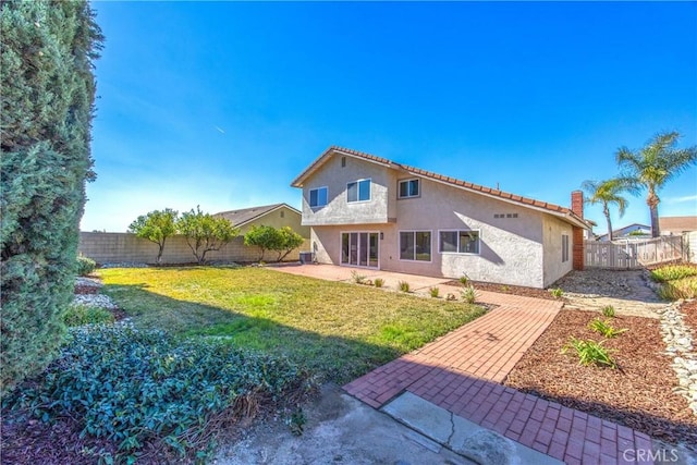 back of property featuring a yard, a fenced backyard, a patio, and stucco siding