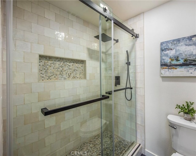 bathroom featuring a shower stall and toilet