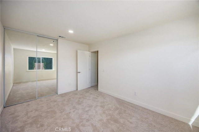 unfurnished bedroom featuring recessed lighting, carpet flooring, visible vents, baseboards, and a closet