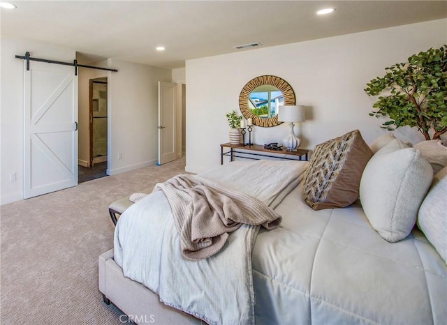 bedroom with a barn door, recessed lighting, carpet flooring, visible vents, and baseboards