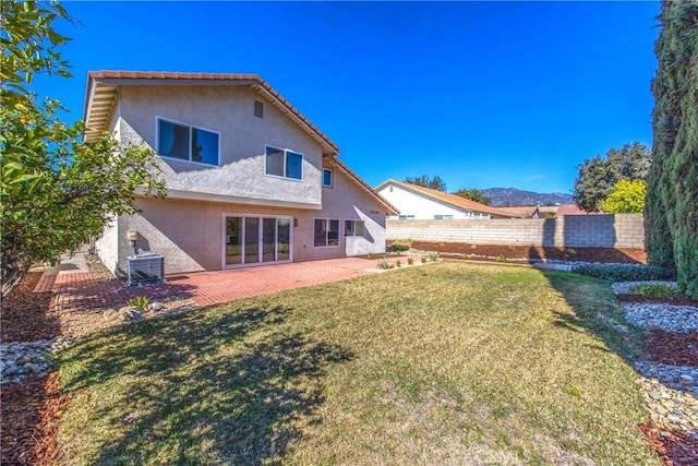 back of house with a lawn, fence, a patio area, central AC, and stucco siding