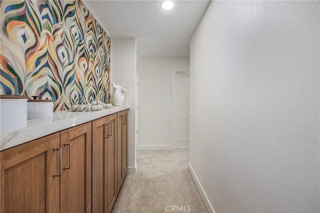 interior space featuring light colored carpet and baseboards