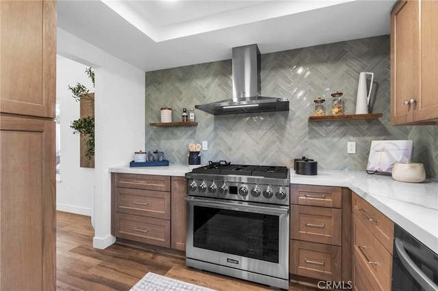 kitchen with open shelves, tasteful backsplash, stainless steel stove, light countertops, and wall chimney range hood