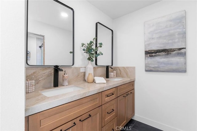 full bath featuring double vanity, decorative backsplash, a sink, baseboards, and tile patterned floors