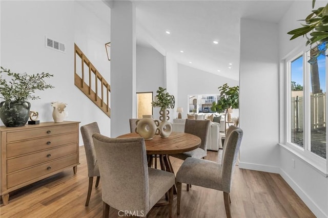 dining space featuring light wood finished floors, baseboards, visible vents, high vaulted ceiling, and recessed lighting