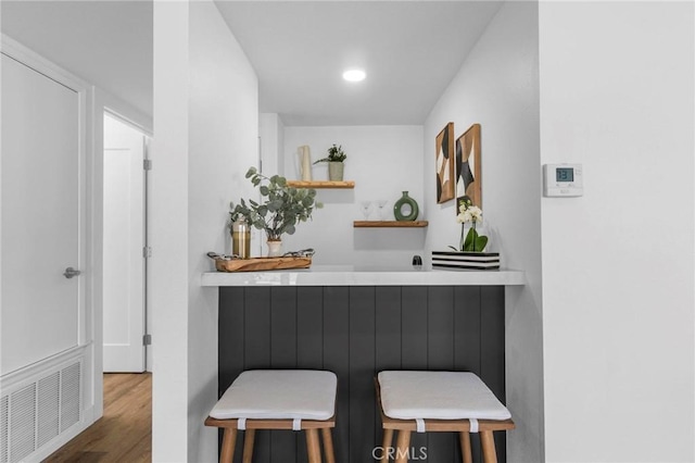 bar featuring indoor bar, wood finished floors, and visible vents