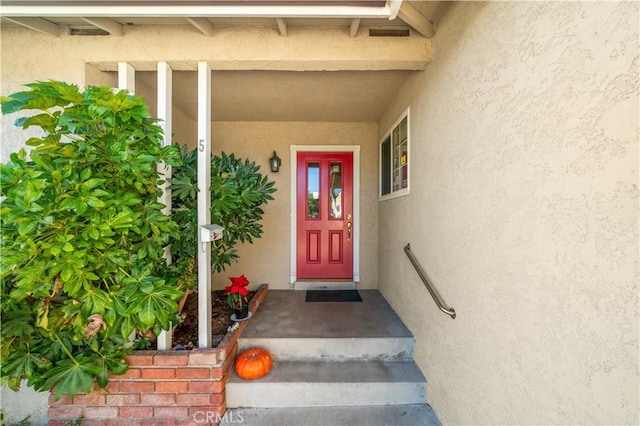 doorway to property featuring stucco siding