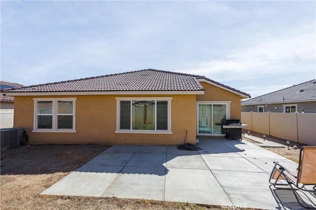 back of house featuring a patio, cooling unit, fence, and stucco siding