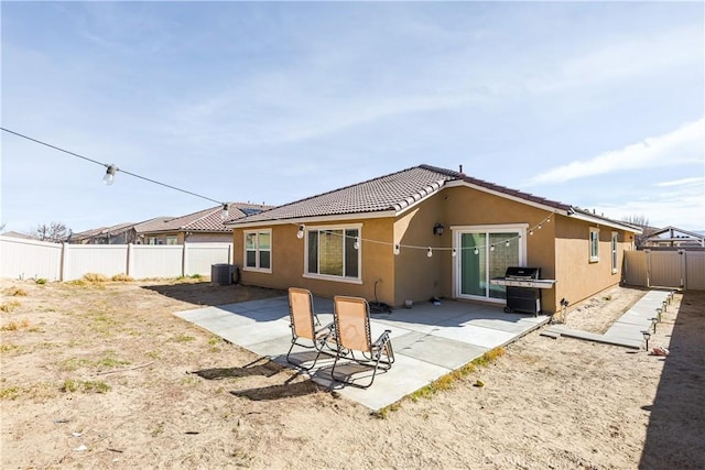 rear view of property featuring a fenced backyard, a patio, and stucco siding