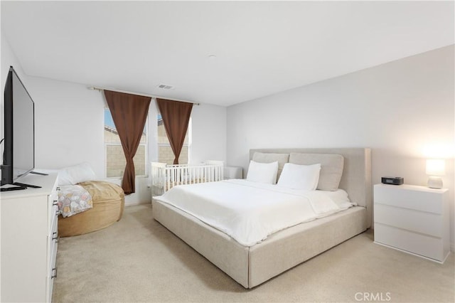 bedroom featuring light colored carpet and visible vents