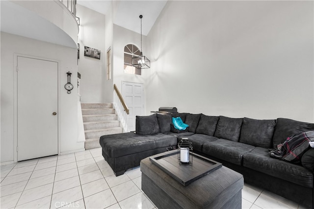 living area with high vaulted ceiling, stairway, a notable chandelier, and light tile patterned flooring