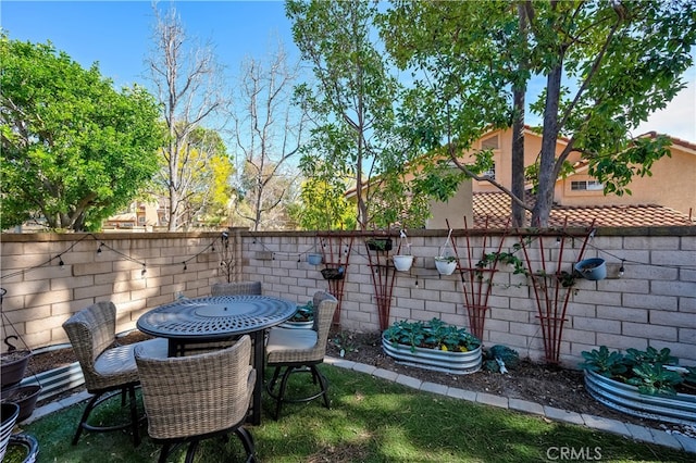 view of yard featuring a fenced backyard and outdoor dining space