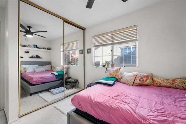 bedroom with ceiling fan, multiple windows, a closet, and carpet flooring