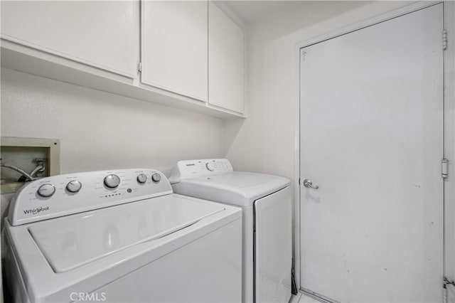 clothes washing area with cabinet space and independent washer and dryer