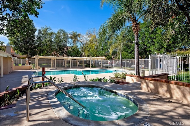 pool with fence and a hot tub