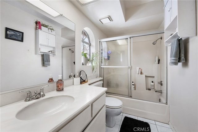 bathroom featuring bath / shower combo with glass door, visible vents, toilet, vanity, and tile patterned floors