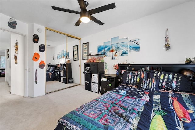 carpeted bedroom featuring ceiling fan and a closet