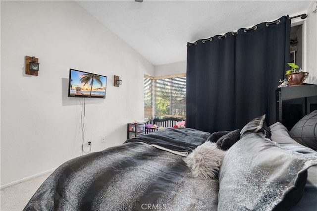 carpeted bedroom featuring lofted ceiling and baseboards