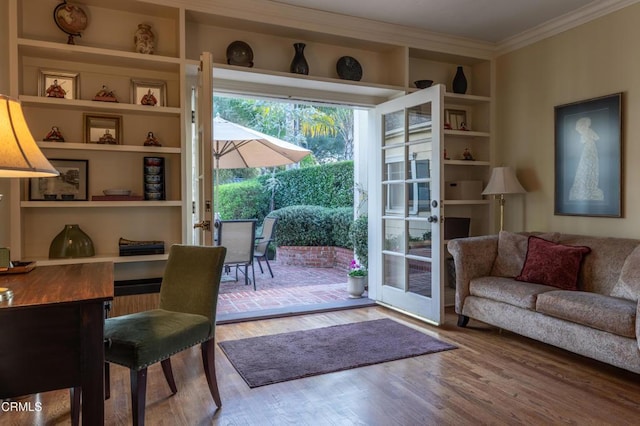 entryway with built in features, ornamental molding, and wood finished floors