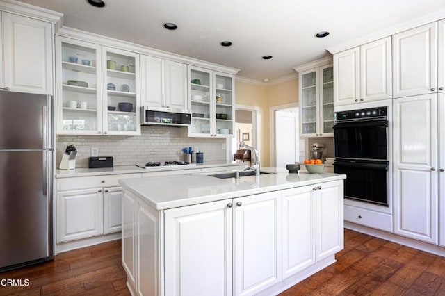 kitchen with white cabinets, glass insert cabinets, stainless steel appliances, and a sink