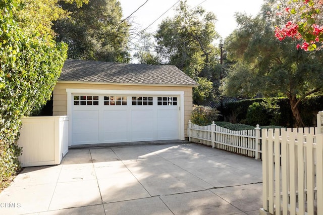 detached garage featuring fence