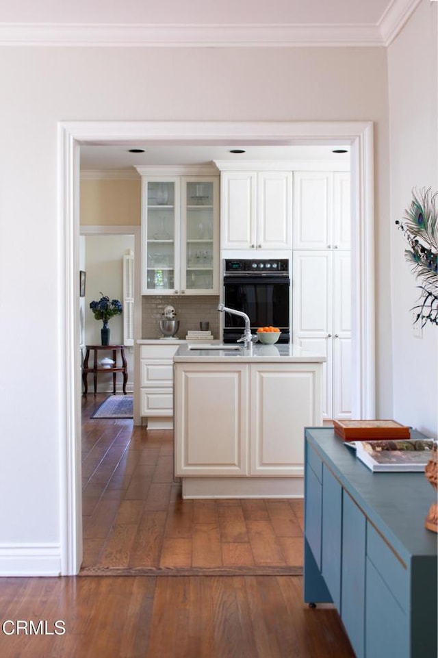 kitchen featuring a sink, glass insert cabinets, and white cabinets