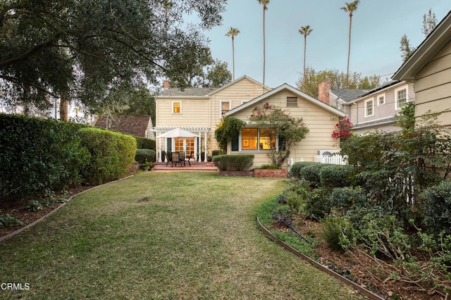 back of property with a lawn and a chimney