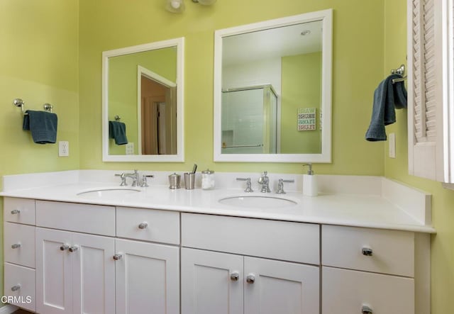 full bath featuring a sink, a shower stall, and double vanity