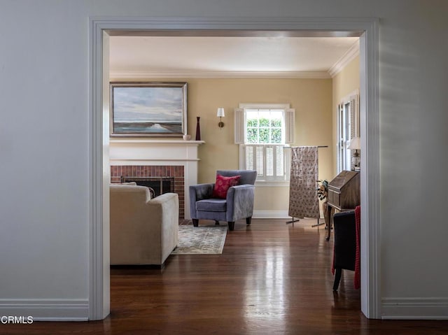 living room featuring dark wood-style floors, a fireplace, baseboards, and crown molding