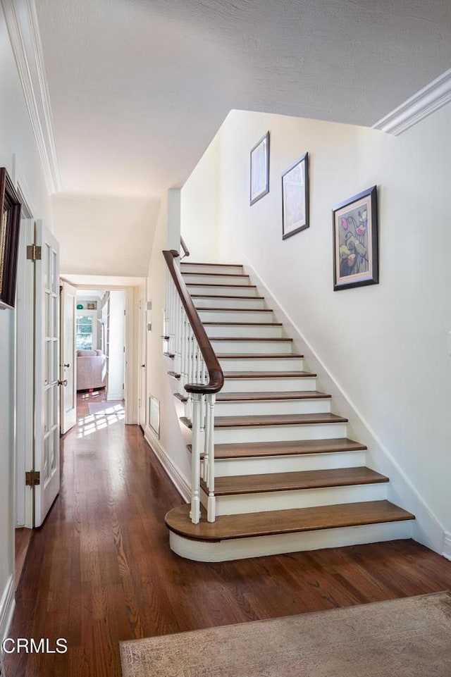 stairway featuring baseboards and wood finished floors