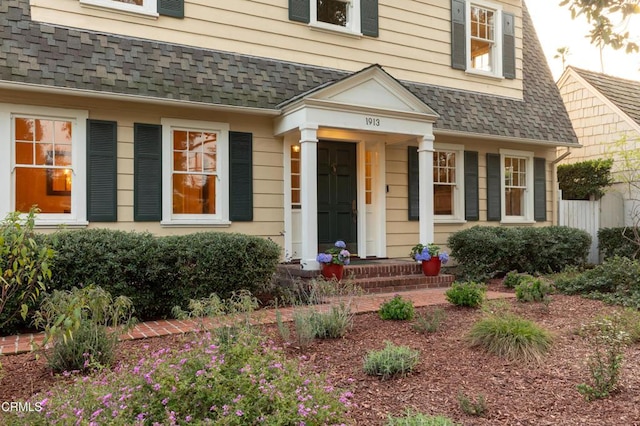 property entrance featuring roof with shingles