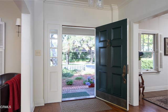 foyer entrance with baseboards, ornamental molding, arched walkways, and dark wood-style flooring