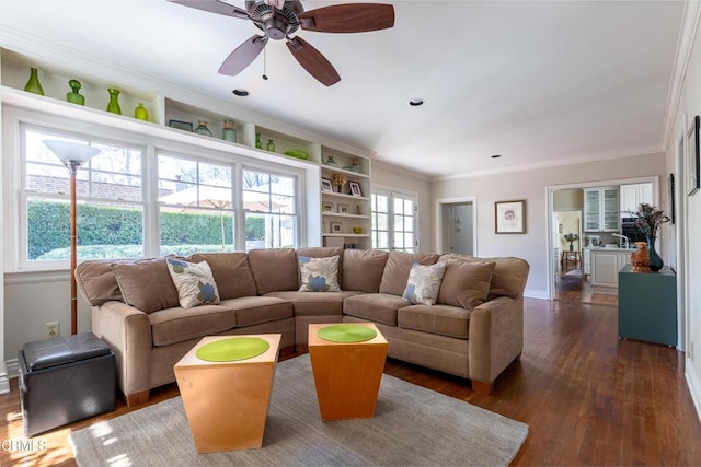 living area featuring baseboards, dark wood finished floors, and crown molding