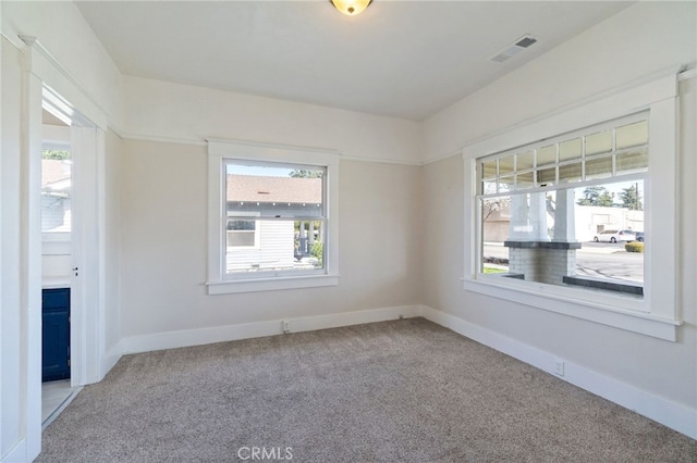 empty room with carpet flooring, a healthy amount of sunlight, and baseboards