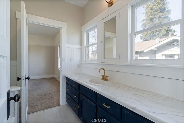 bathroom featuring tile patterned floors, vanity, and wainscoting