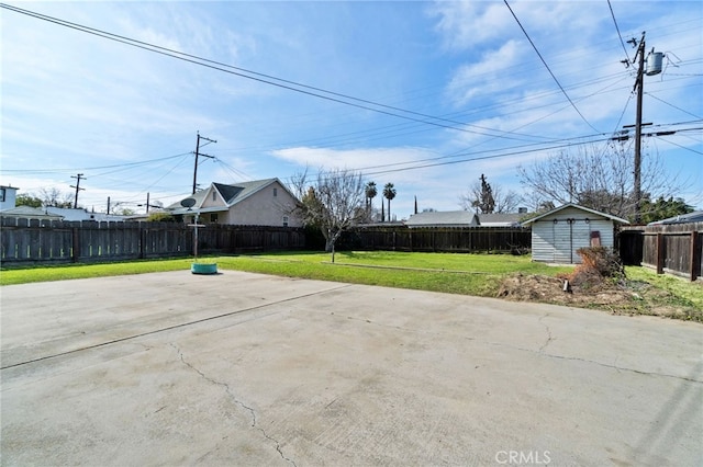 view of patio / terrace with an outbuilding, a storage unit, and a fenced backyard