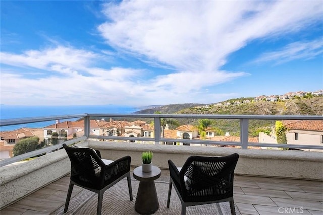 balcony featuring a water view and a residential view