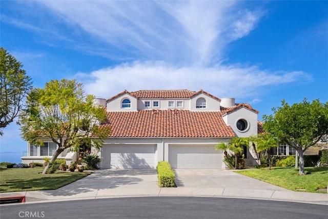 mediterranean / spanish-style home featuring a tile roof, stucco siding, a garage, driveway, and a front lawn