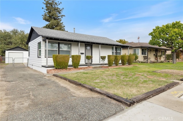 view of front of home featuring a front yard, a shingled roof, an outdoor structure, a garage, and aphalt driveway