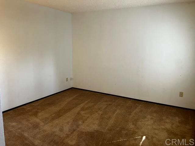 spare room featuring a textured ceiling and carpet flooring