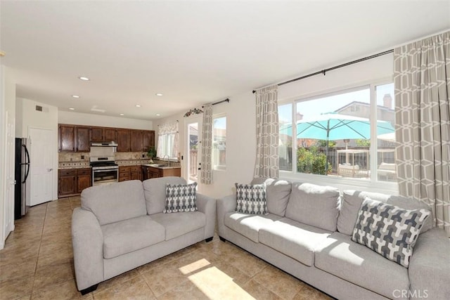 living area featuring light tile patterned floors, visible vents, and recessed lighting