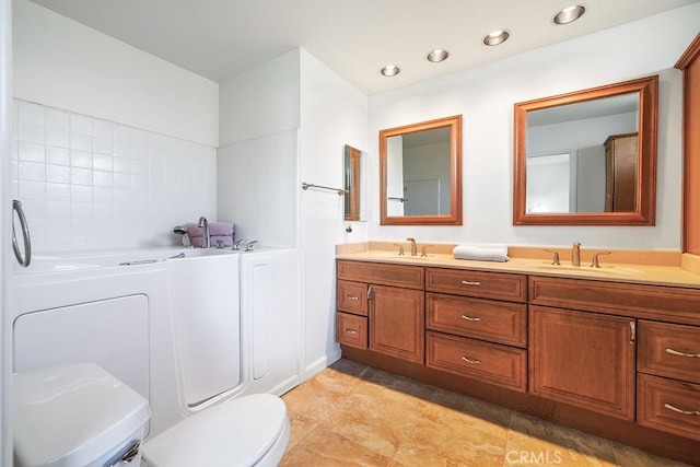 full bathroom with a garden tub, double vanity, a sink, and toilet