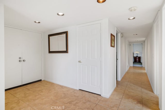 corridor with light tile patterned flooring, baseboards, and recessed lighting