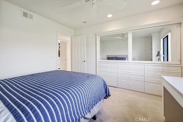 bedroom featuring recessed lighting, visible vents, light carpet, and a textured ceiling