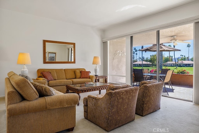 living area with ceiling fan and light colored carpet