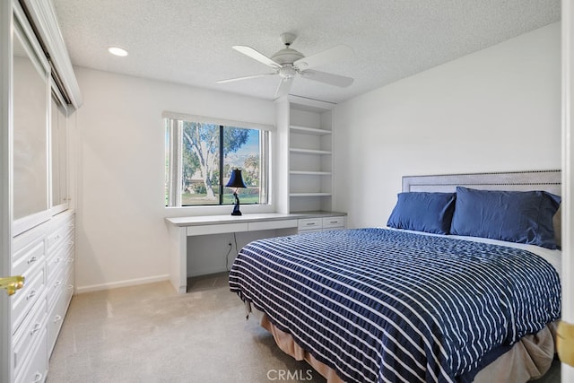 bedroom featuring a ceiling fan, baseboards, a textured ceiling, and light colored carpet