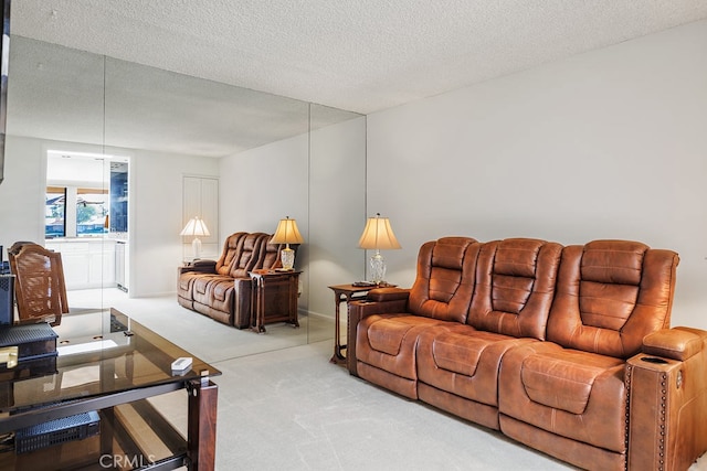 living area featuring light carpet and a textured ceiling